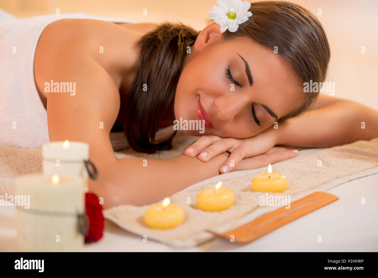 Cute young woman enjoying during a skin care treatment at a spa. Stock Photo