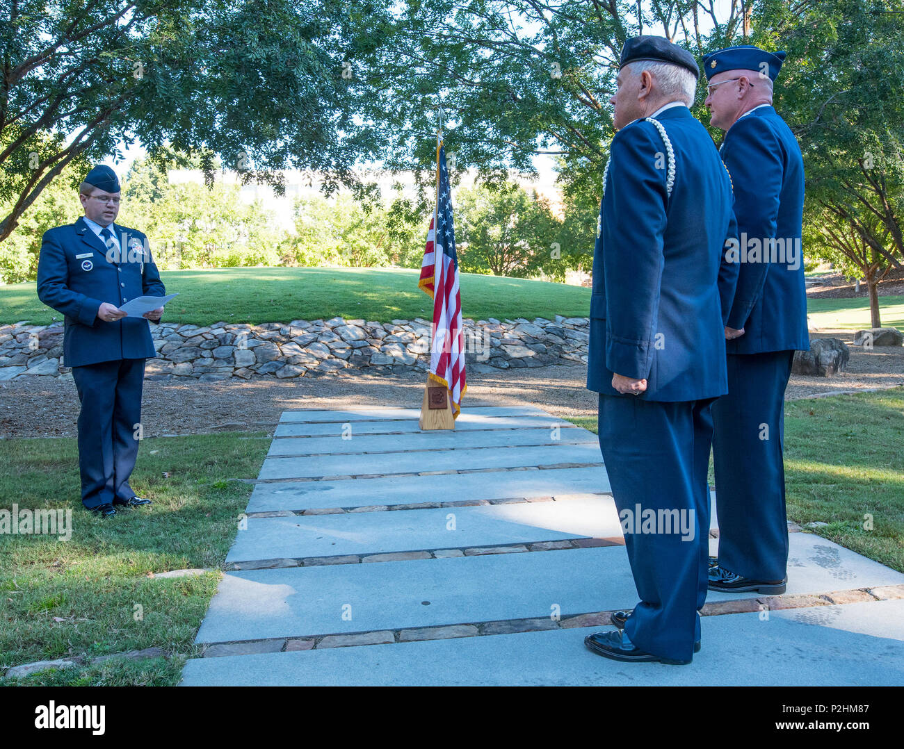 U.S. Air Force Maj. Brock Lusk reads the orders during the promotion ceremony of Lt. Col. Michael E. Mac Lain (far right) during a ceremony at the Scroll of Honor in Clemson University’s Memorial Park, Sept. 30, 2016. Mac Lain is the Aeromedical Operations Flight Commander for the 43rd  Aeromedical Evacuation Squadron, Pope Army Airfield, Fort Bragg, NC. He directs daily flight operations for 60 assigned personnel, and provides medical care as a Flight Nurse on aeromedical evacuation missions. Mac Lain has deployed nine times to combat zones and successfully aero medically evacuated over 700 o Stock Photo