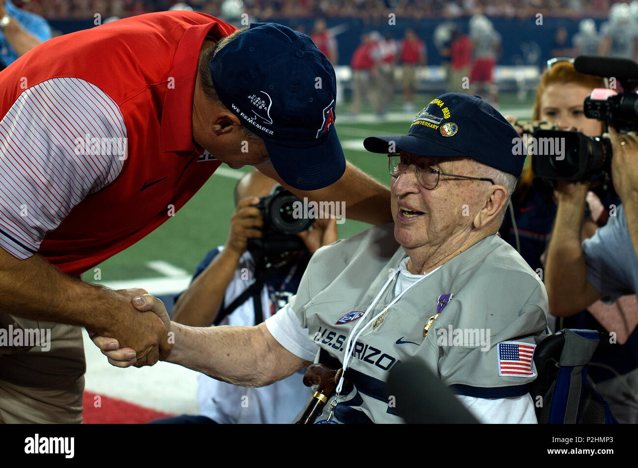 Rich Rodriguez, head coach of the Arizona Wildcats football team, shakes hands with Lauren Bruner, survivor of the Dec. 7, 1941 attack on Pearl Harbor, at Arizona Stadium in Tucson, Ariz., Sept. 17, 2016. Bruner was honored throughout the Arizona Wildcats vs. Hawaii Rainbow Warriors football game commemorating the 75th anniversary of the Japanese attack on Pearl Harbor Dec. 7, 1941. (U.S. Air Force photo by Senior Airman Chris Drzazgowski) Stock Photo