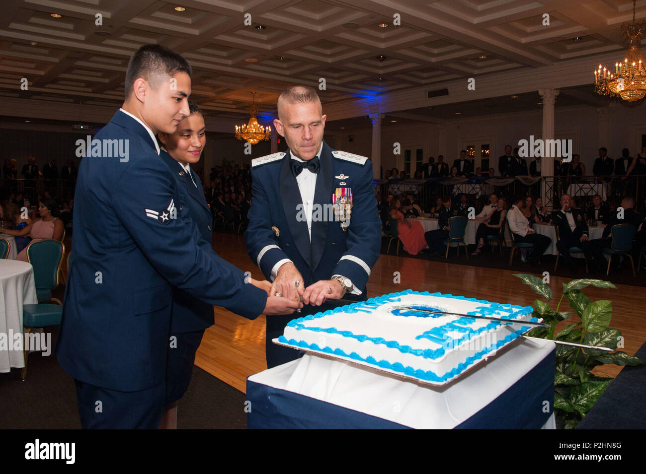 Maxwell AFB, Ala. - (L-R) Airmen First Class Anthony Fox and Maria Ramirez join Lieutenant General Steven Kwast, Commander and President, Air University, in cutting the ceremonial cake for the 2016 Air Force Ball celebrating the 69th Birthday of the United States Air Force on Sep 16, 2016. (US Air Force photo by Bud Hancock/Released) Stock Photo