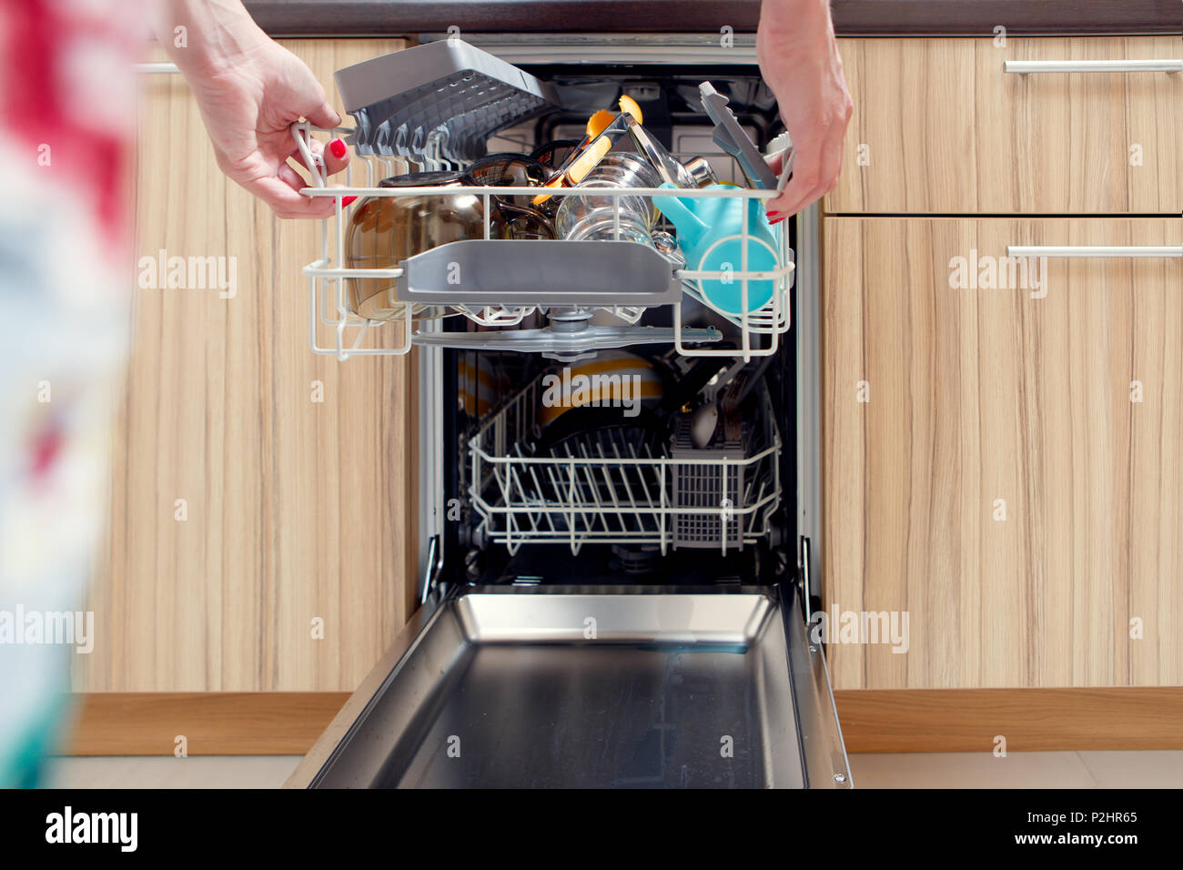 Image of girl's hand opening dishwasher with dirty dishes Stock Photo
