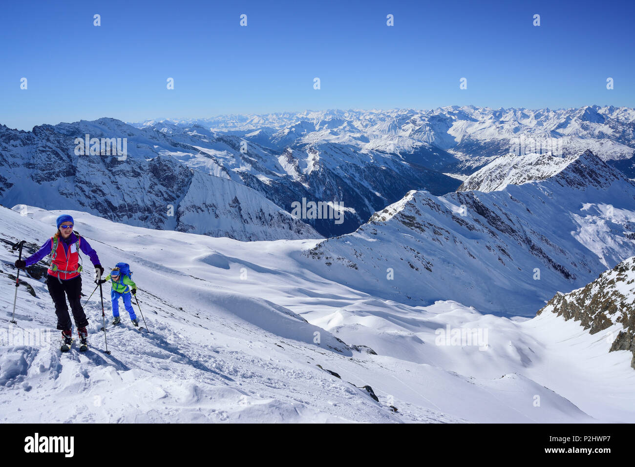 Two persons back-country skiing ascending towards Kleiner Kaserer, Stubai Alps and Zillertal Alps in the background, Hoellschart Stock Photo