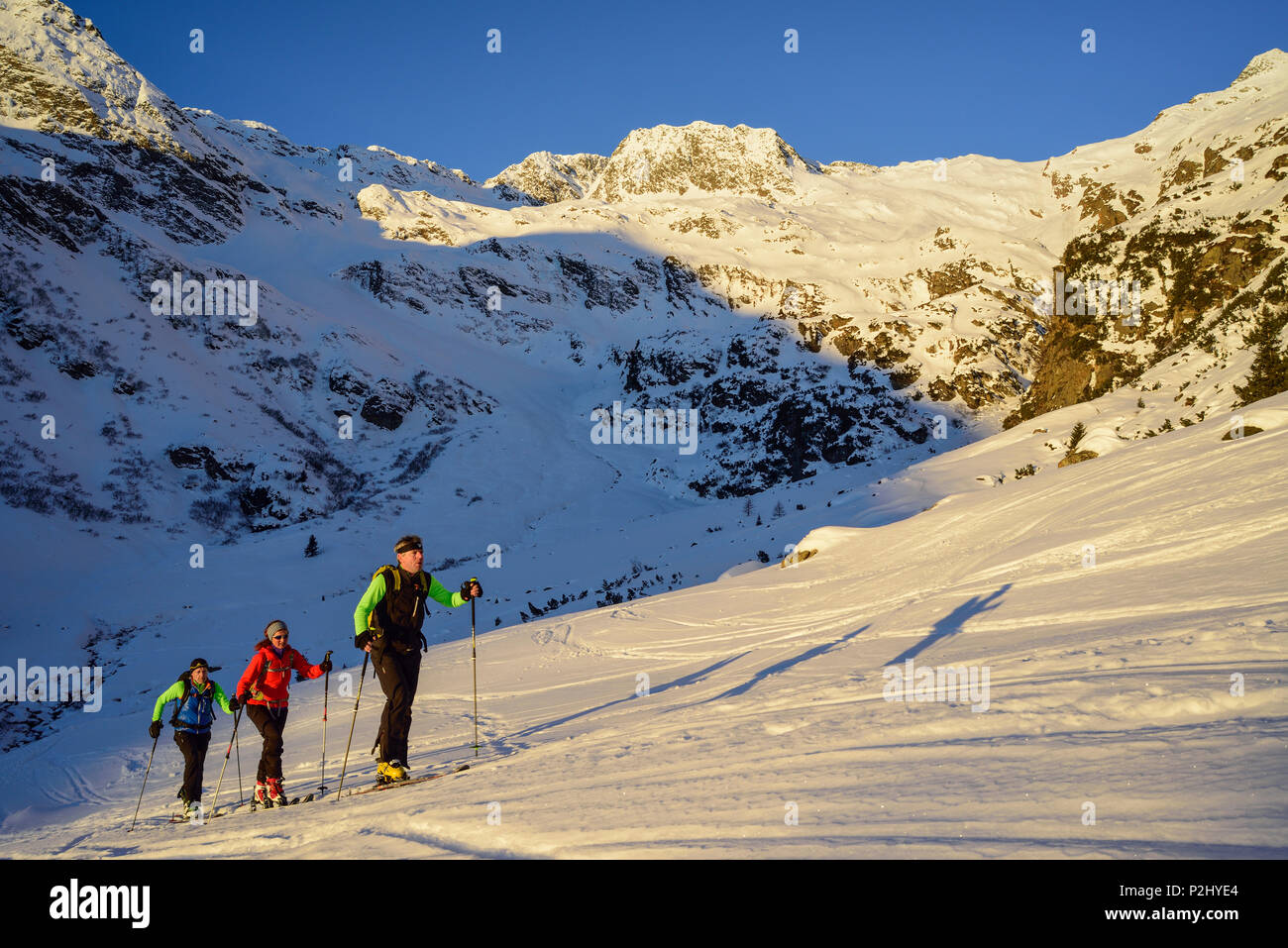 Three persons back-country skiing ascending towards Schneespitze, Schneespitze, valley of Pflersch, Stubai Alps, South Tyrol, It Stock Photo