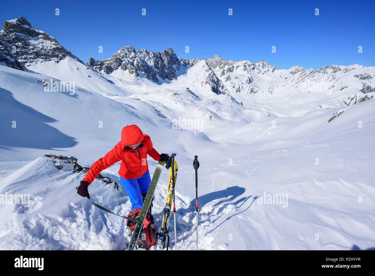 Woman back-country skiing stripping off the skins, Rocca Blancia, Parias Coupa, Brec de Chambeyron and Aiguille de Chambeyron in Stock Photo