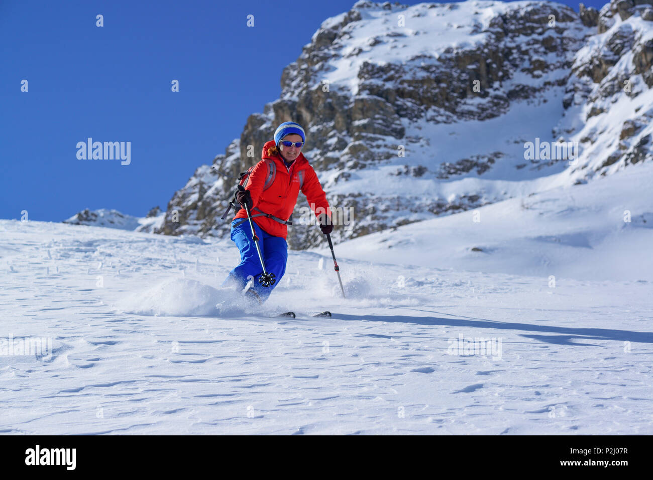 Woman back-country skiing downhill through powdersnow from Passo Croce, Passo Croce, Valle Maira, Cottian Alps, Piedmont, Italy Stock Photo
