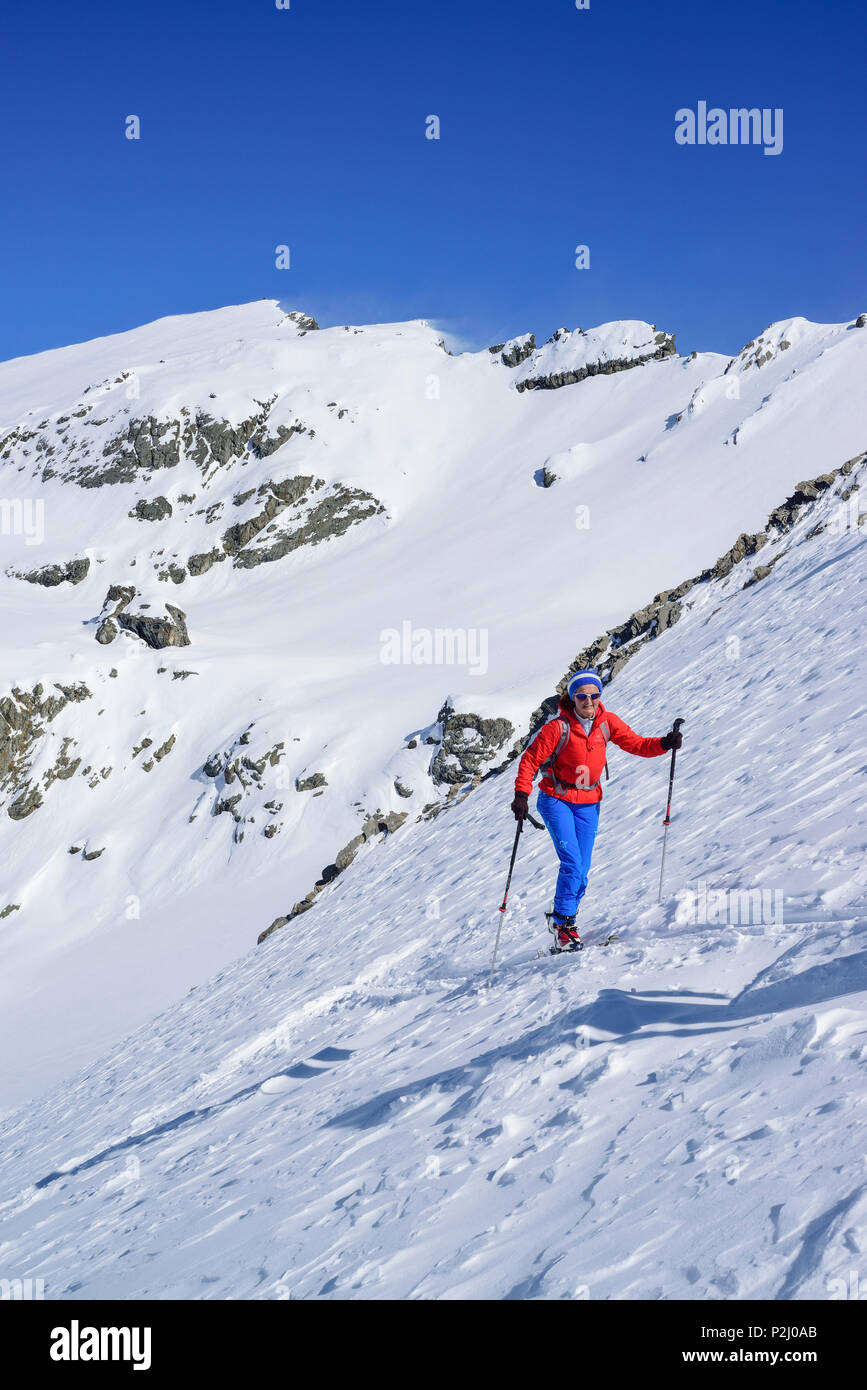 Woman back-country skiing ascending towards Monte Faraut, Monte Faraut, Valle Varaita, Cottian Alps, Piedmont, Italy Stock Photo