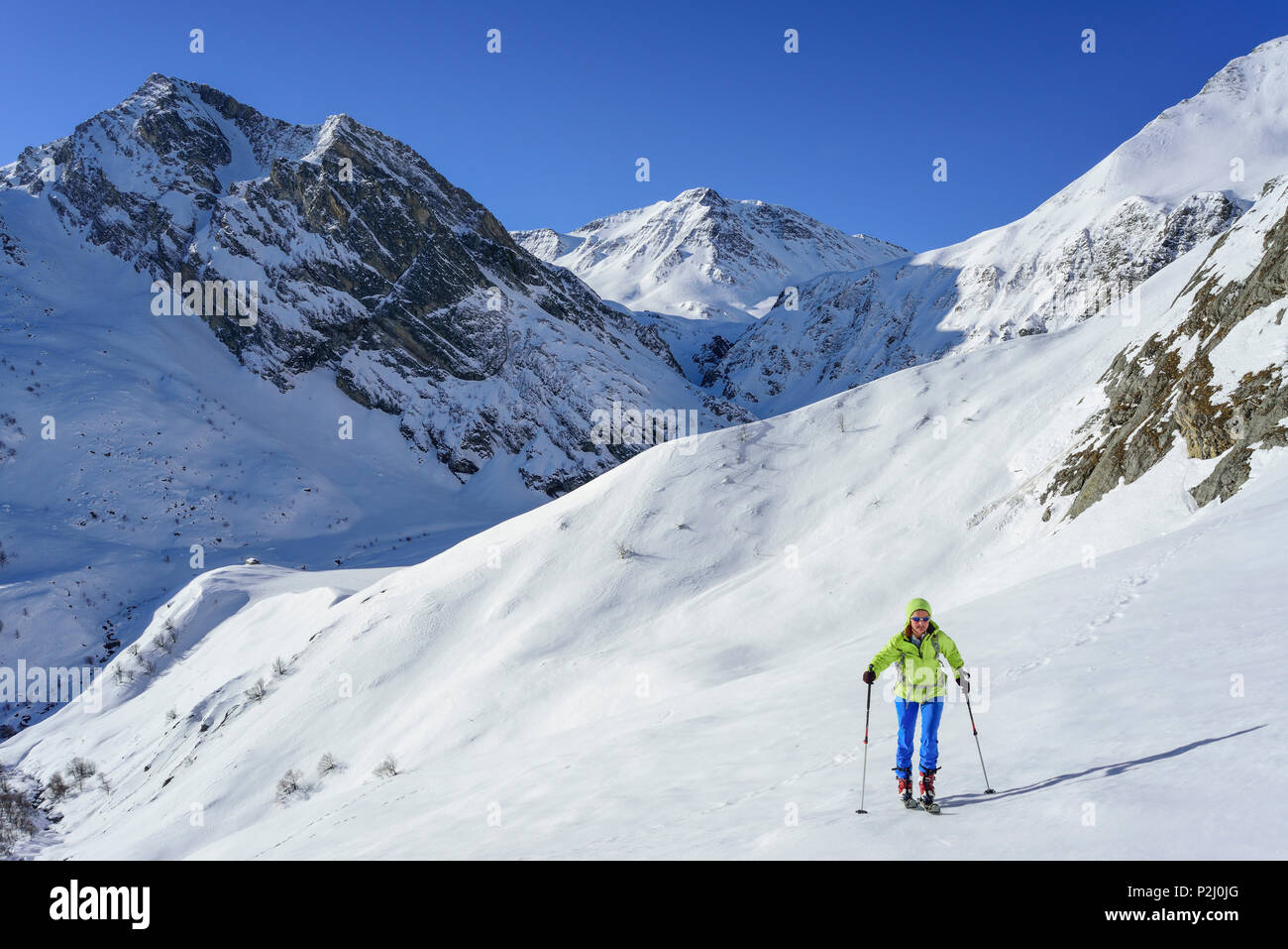 Woman back-country skiing ascending towards Monte Salza, in background Monte Pence and Buc Faraut, Monte Salza, Valle Varaita, C Stock Photo