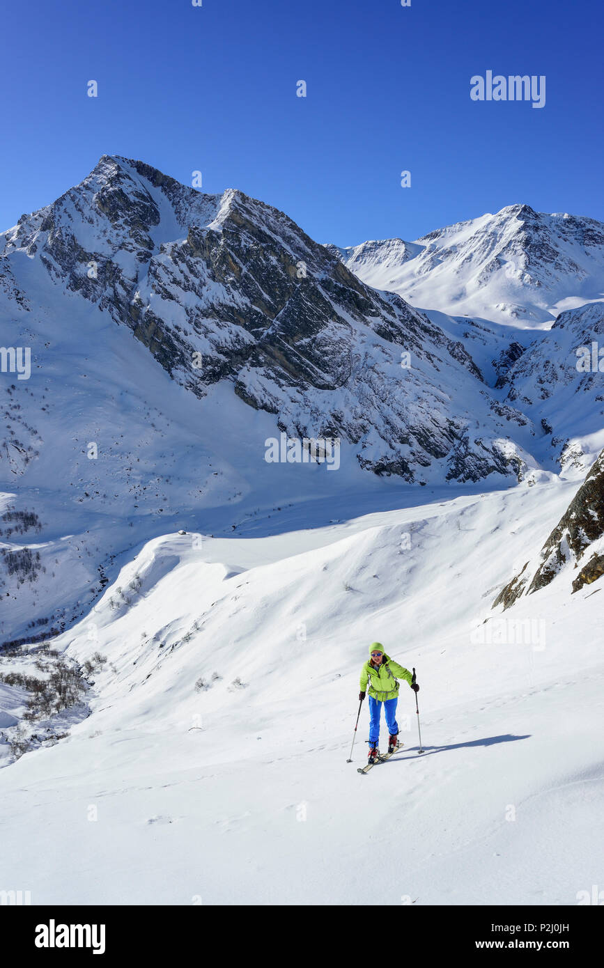 Woman back-country skiing ascending towards Monte Salza, in the background Monte Pence and Buc Faraut, Monte Salza, Valle Varait Stock Photo