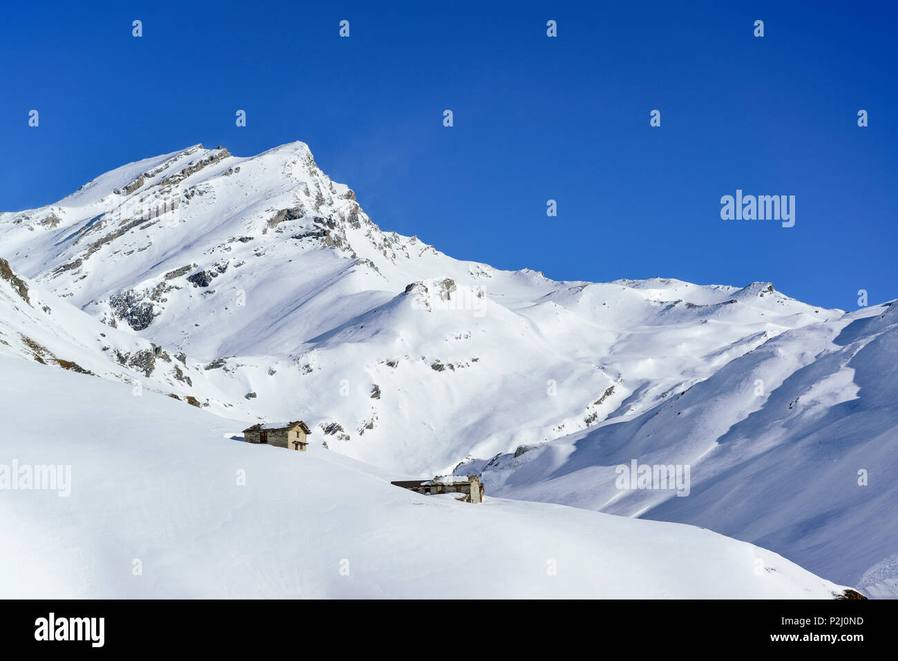Snow-covered alpine huts in front of Monte Salza, Monte Salza, Valle Varaita, Cottian Alps, Piedmont, Italy Stock Photo
