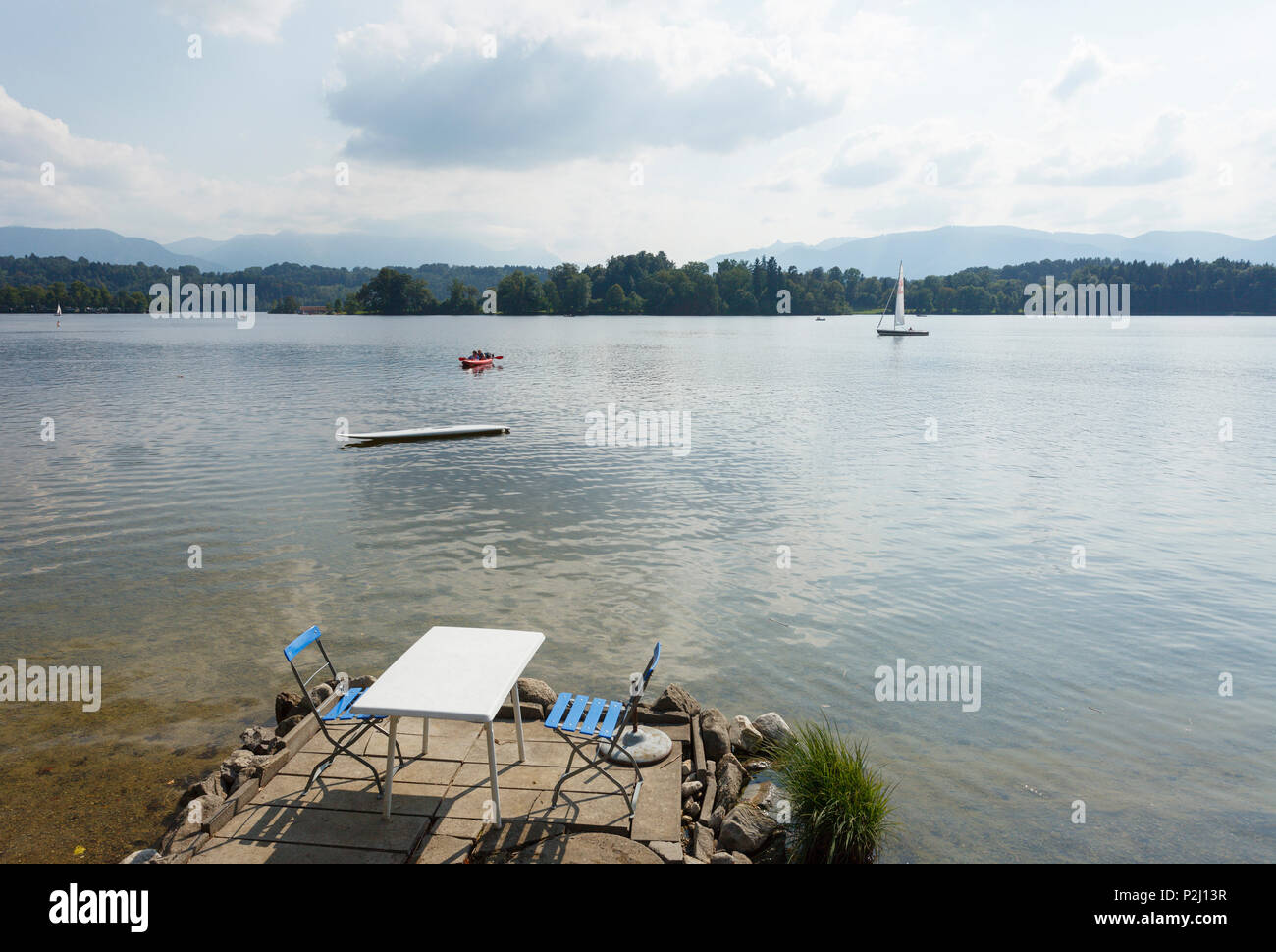 Table and chairs on the banks of Buchau island, Staffelsee, near Murnau, Blue Land, district Garmisch-Partenkirchen, Bavarian al Stock Photo