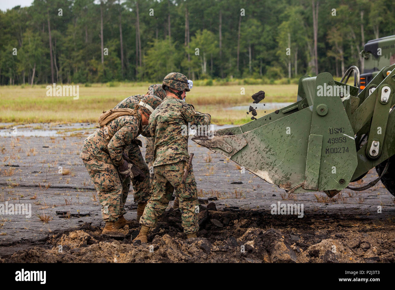 U.S. Marines assigned to Marine Wing Support Squadron (MWSS) 274, throw large pieces of concrete into a Tractor, Rubber-tired, Articulated, Multipurpose, 624KR vehicle during a Base Recovery After Attack (BRAAT) drill at Camp Davis, Marine Corps Base Camp Lejeune, N.C., Sept 22, 2016. MWSS-274 Conducted the BRAAT drill as part of an annual field training exercise to improve unit operability and strengthen operational readiness. (U.S. Marine Corps photo by Lance Cpl. Anthony J. Brosilow/Released) Stock Photo