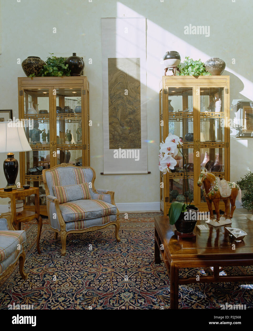 Glass Fronted Cabinets On Either Side Of Scroll On Wall Of