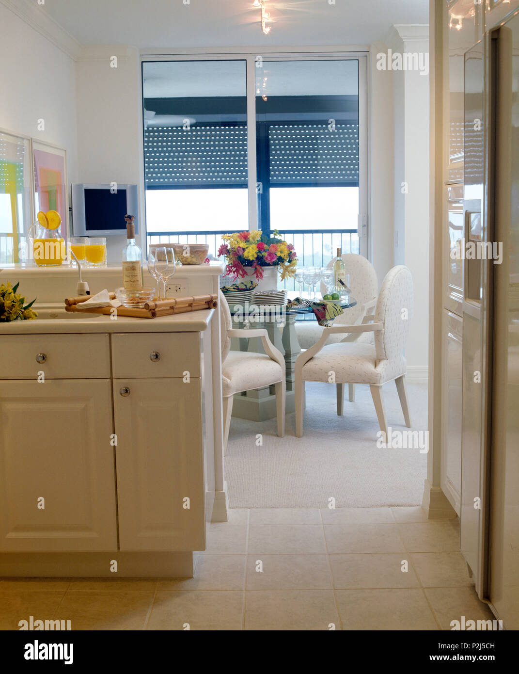 Cream chairs and glasstopped table in kitchen dining room Stock Photo Alamy