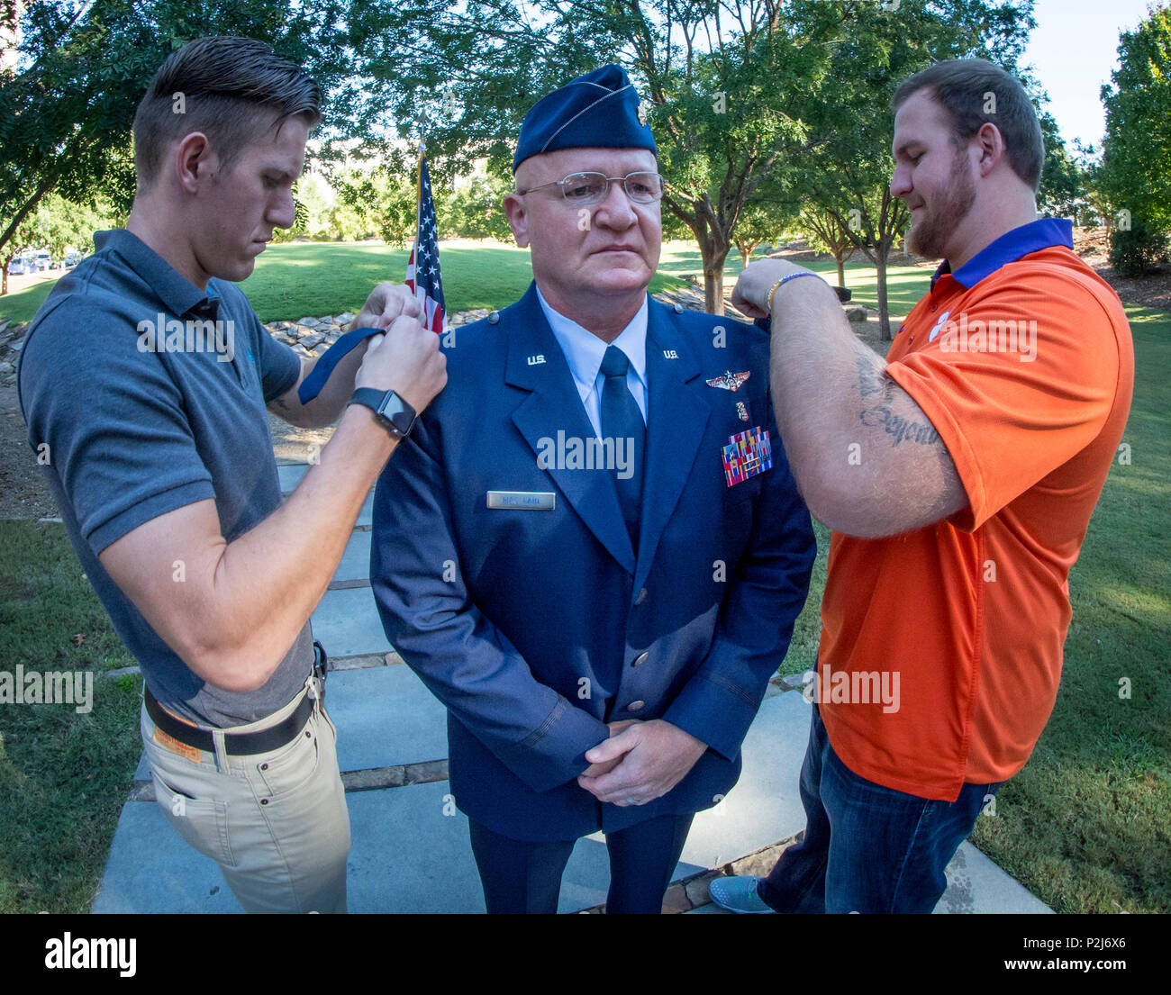 Clemson Tigers football players Sean and Eric Mac Lain pin the rank of lieutenant colonel on their father, U.S. Air Force Lt. Col. Michael E. Mac Lain, during a ceremony at the Scroll of Honor in Clemson University’s Memorial Park, Sept. 30, 2016. Mac Lain, of Lillington, N.C., is the Aeromedical Operations Flight Commander for the 43rd  Aeromedical Evacuation Squadron, Pope Army Airfield, Fort Bragg, NC. He directs daily flight operations for 60 assigned personnel, and provides medical care as a Flight Nurse on aeromedical evacuation missions. Mac Lain has deployed nine times to combat zones  Stock Photo