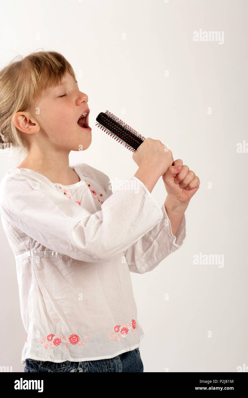 Hairbrush diva young girl singing into her hairbrush Stock Photo Alamy