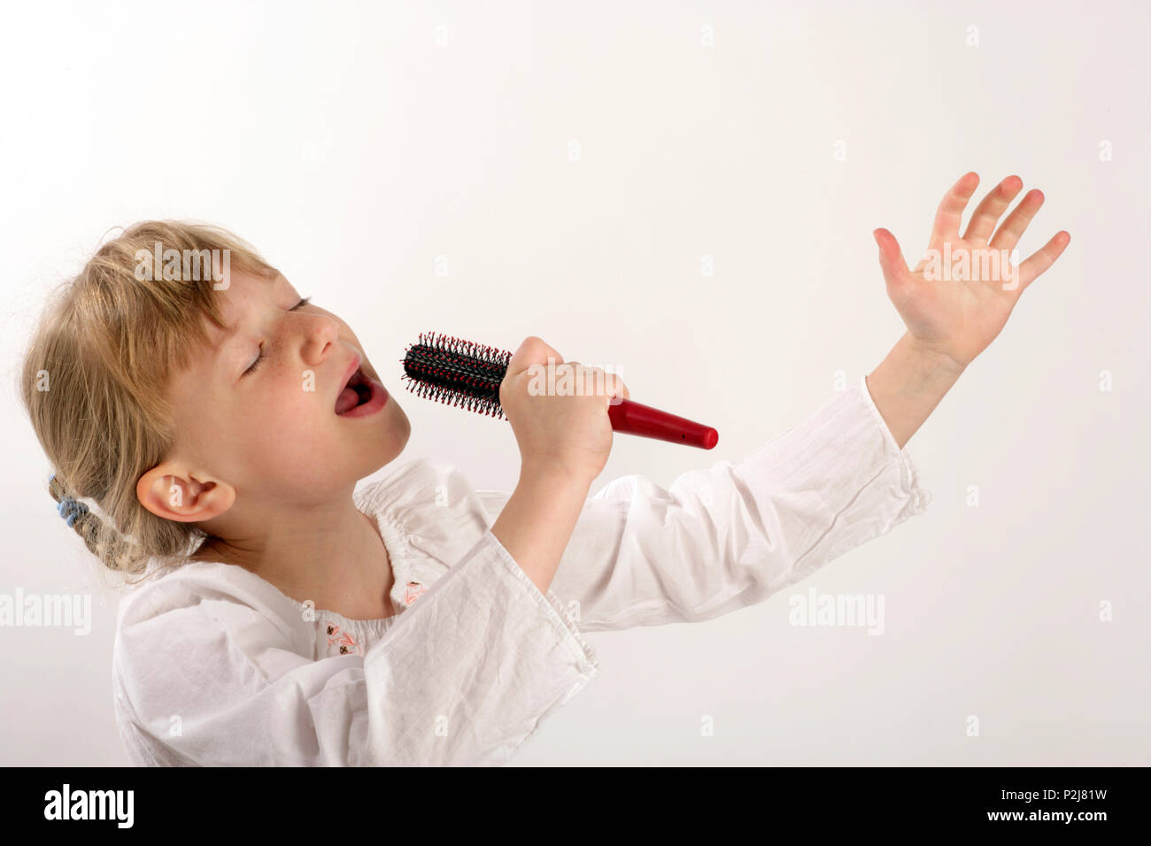 Hairbrush diva or divas. Young girl singing into her hairbrush Stock ...