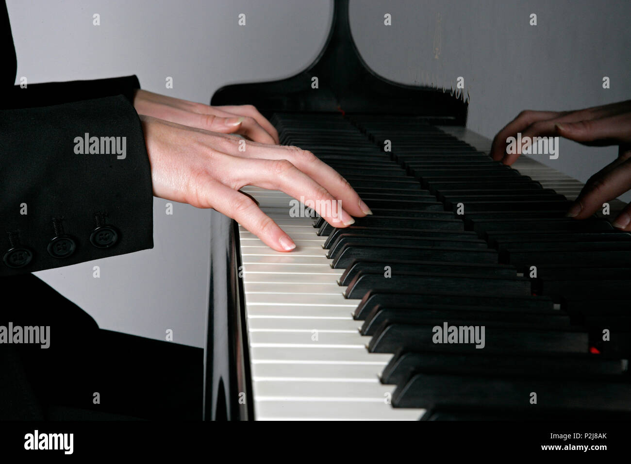 young woman playing the grand piano Stock Photo