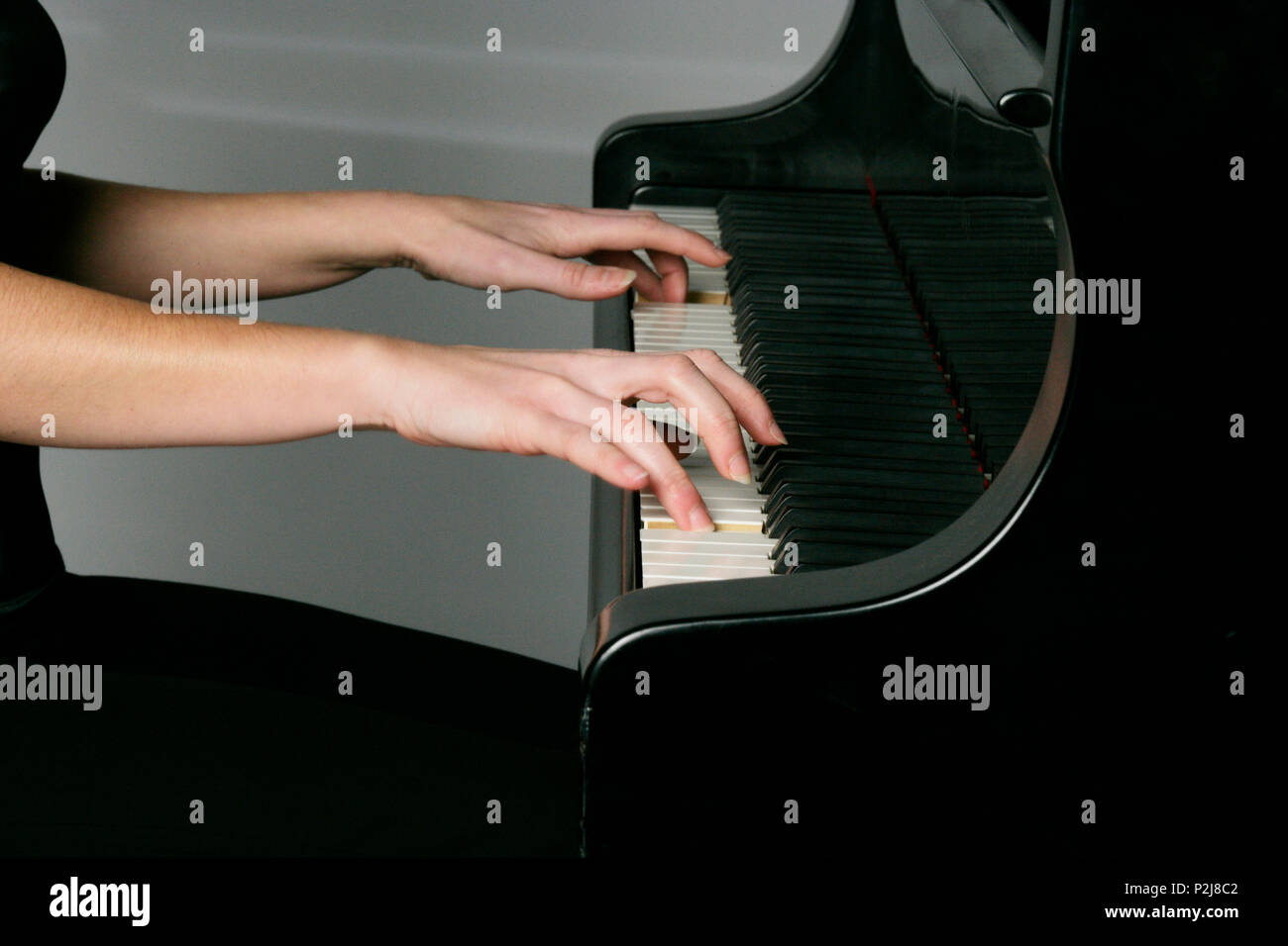 young woman playing the grand piano Stock Photo