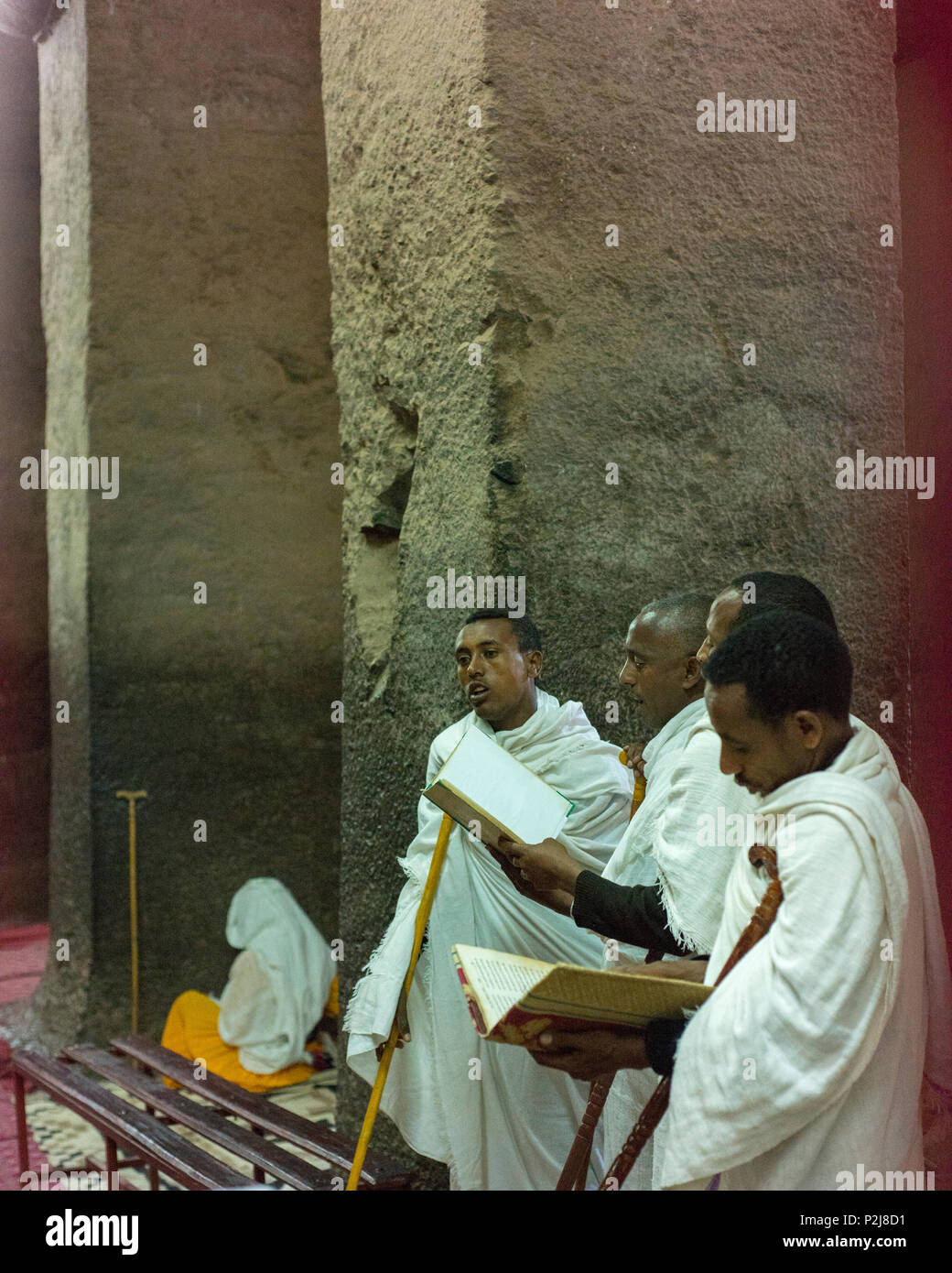 Men chant in one of Lalibela's rock-cut churches. Stock Photo