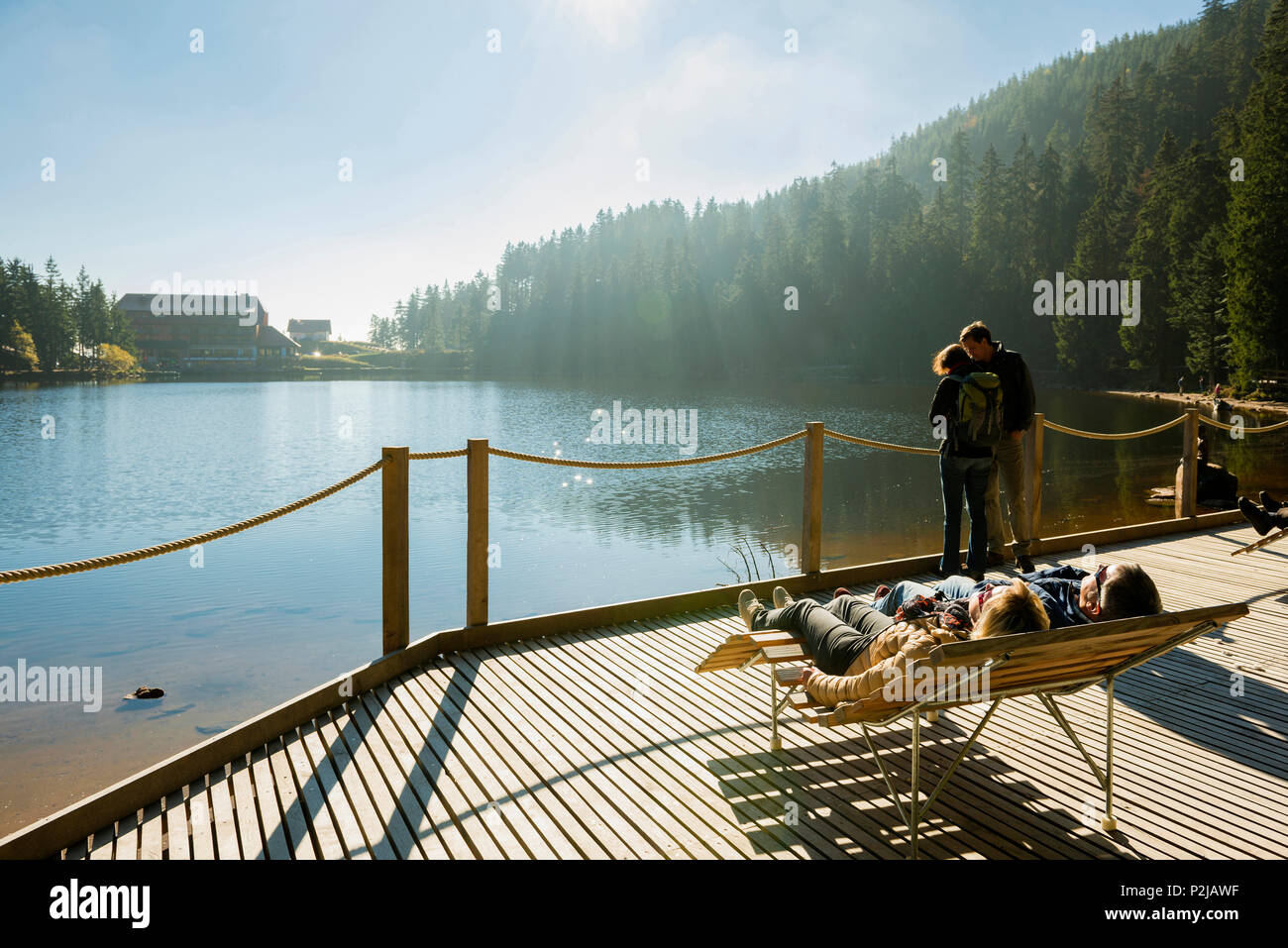 Couple sunbathing at Lake Mummelsee, Seebach, near Achern, Black Forest, Baden-Wuerttemberg, Germany Stock Photo