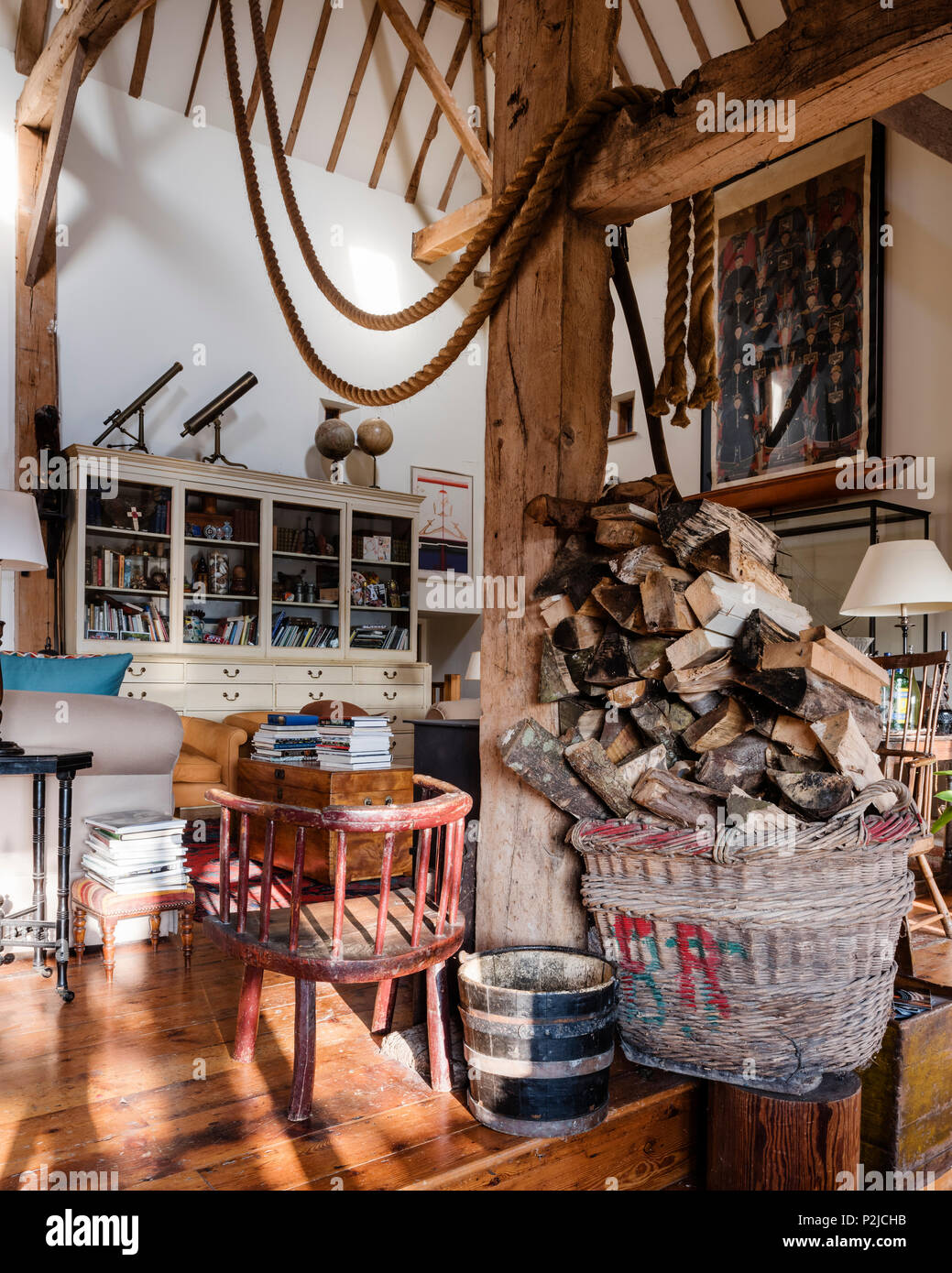 Ship ropes with firewood in log basket in Sussex barn conversion Stock Photo