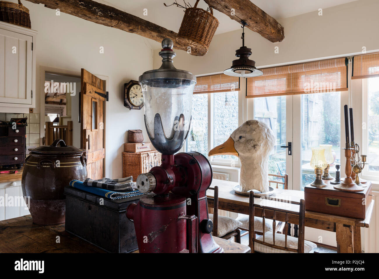 American 1920’s coffee grinder and large goose head in kitchen of Sussex barn conversion Stock Photo
