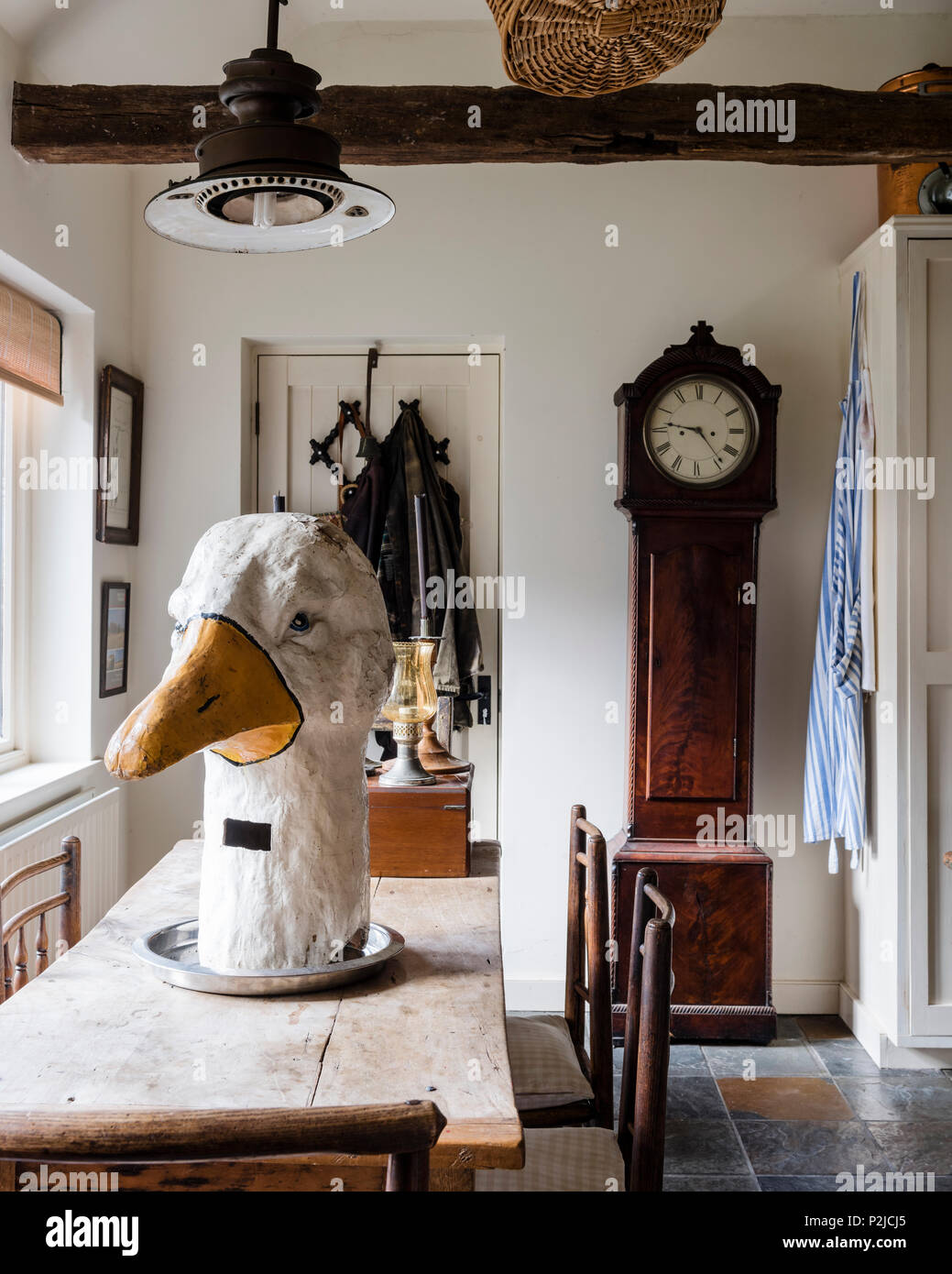 Early 18th century Scottish longcase clock and large goose head in kitchen of Sussex barn conversion Stock Photo