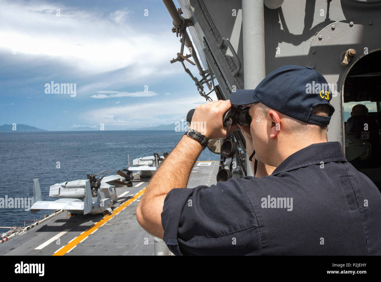 160927-N-WF272-036 WATERS NEAR THE PHILIPPINES (Sept. 27, 2016) Lt. Cmdr. Joseph Teixeira views Philippines from the bridge of amphibious assault ship USS Bonhomme Richard (LHD 6). Bonhomme Richard, flagship of the Bonhomme Richard Expeditionary Strike Group, is operating in waters near Philippines in support of security and stability in the Indo-Asia Pacific region. (U.S. Navy photo by Mass Communication Specialist 2nd Class Diana Quinlan/Released) Stock Photo