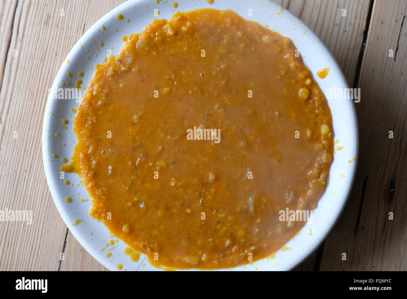 A bowl of badly poured soup. Stock Photo