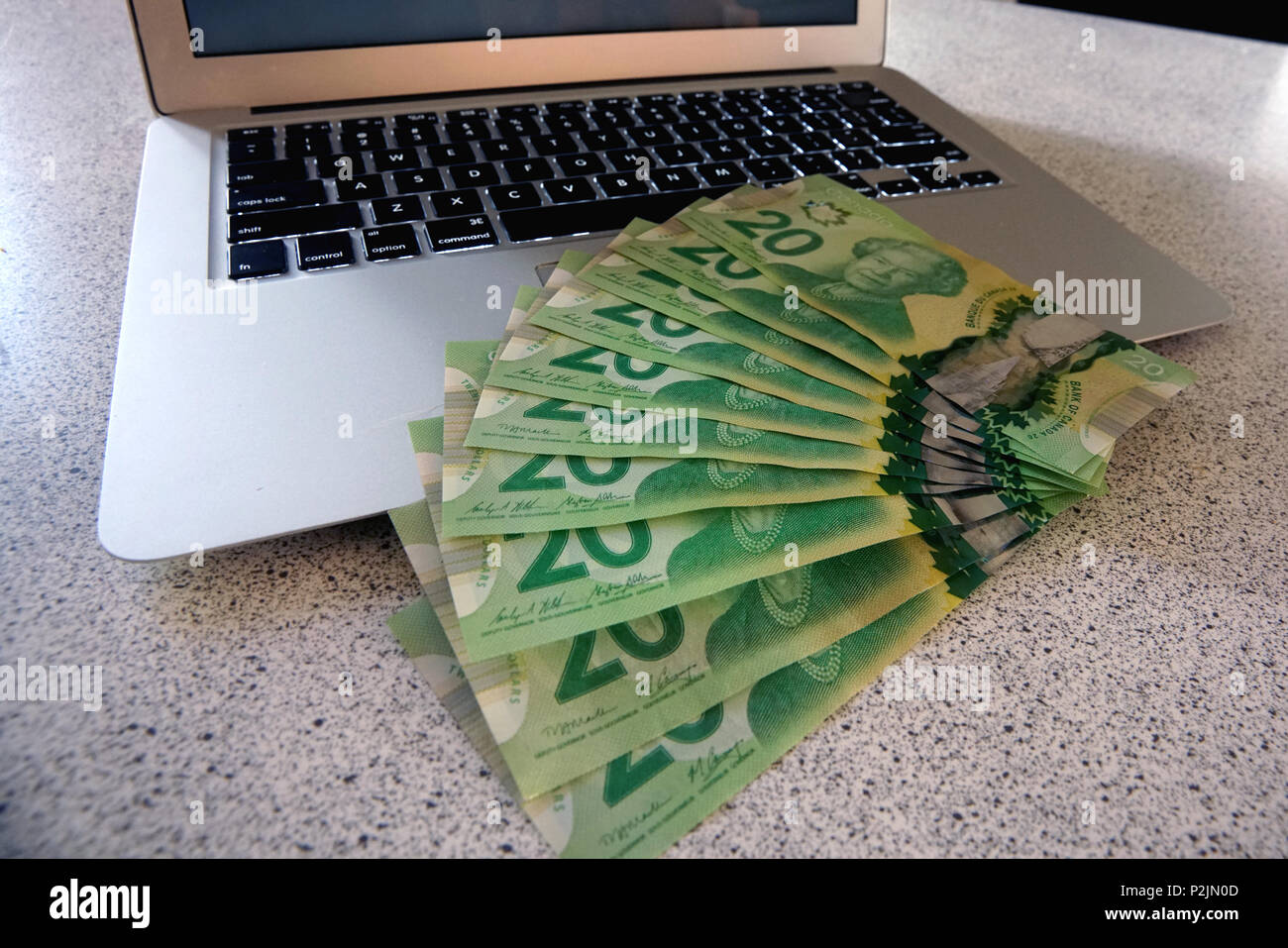 Montreal,Canada,15 June 2018.Display of 20 dollar bills of Canadian currency on a laptop computer.Credit:Mario Beauregard/Alamy Live News Stock Photo