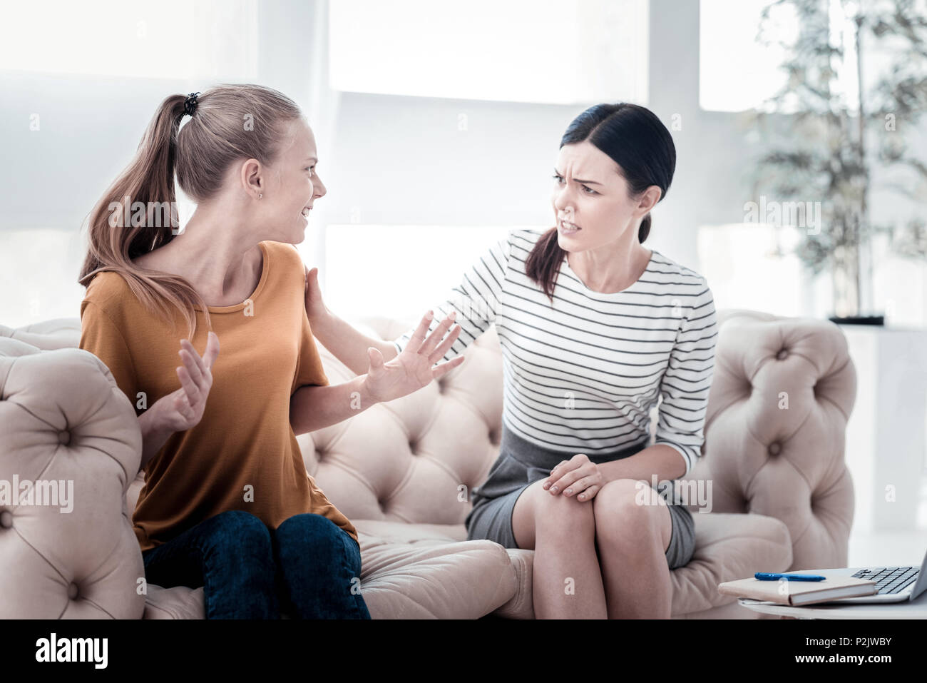 Teenager expressing irritation during psychological appointment Stock