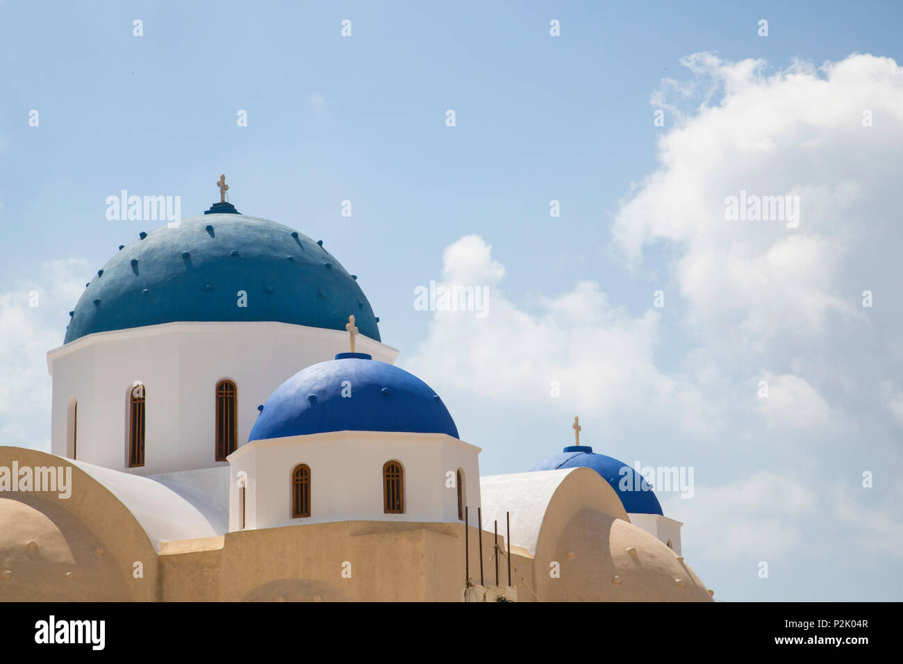 brightly azure blue coloured greek chapel roofs on cyclade island Santorini with summer sky Stock Photo