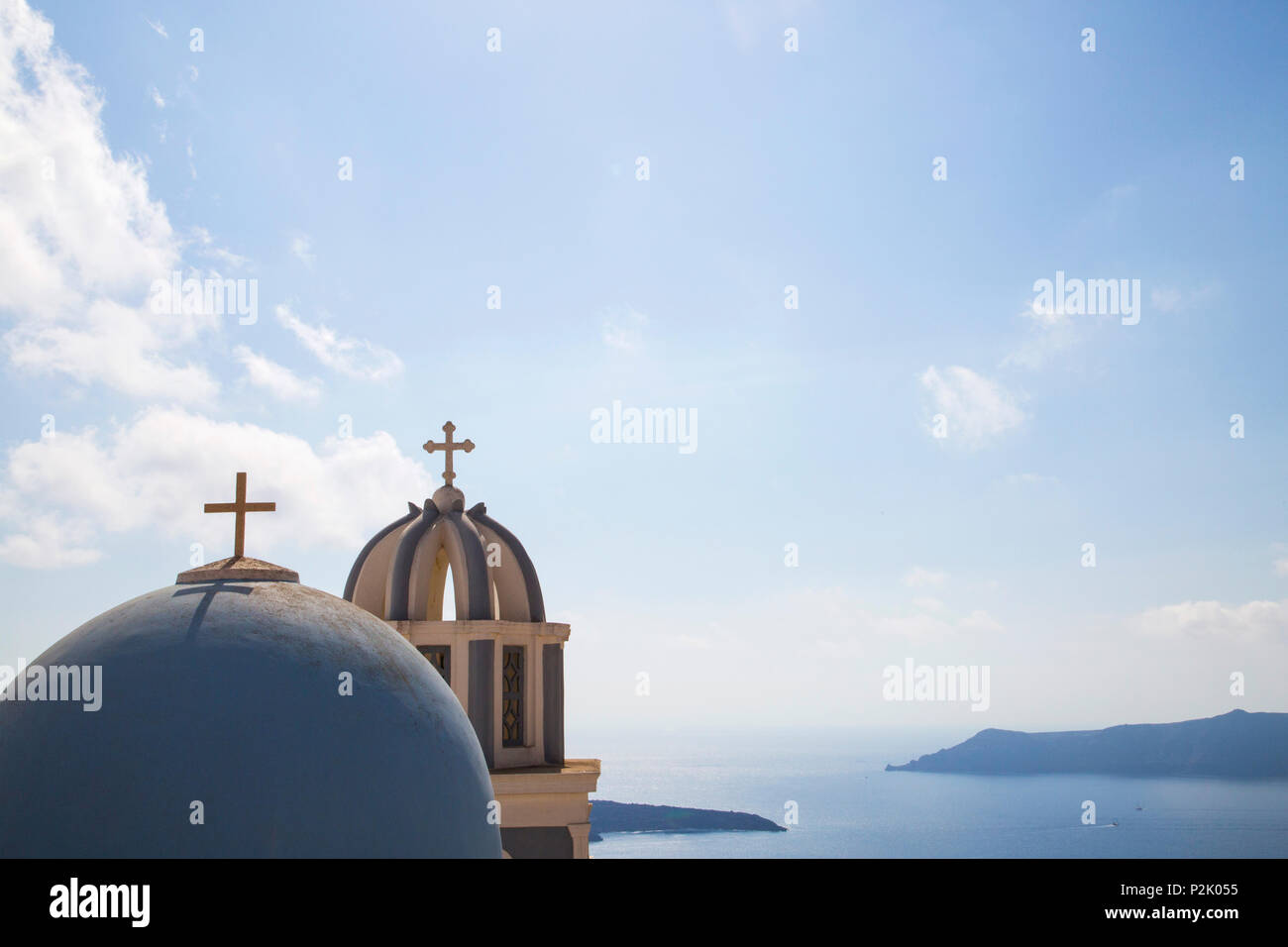 blue painted chapel domes on aegean island Santorini with summer sky and view over sea Stock Photo