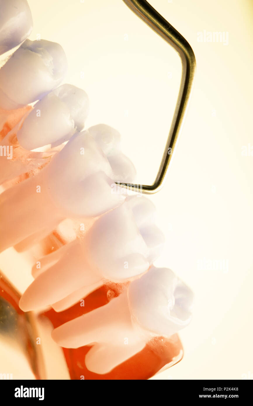 Dentist cleaning teeth with titanium metal tooth pick instrument to