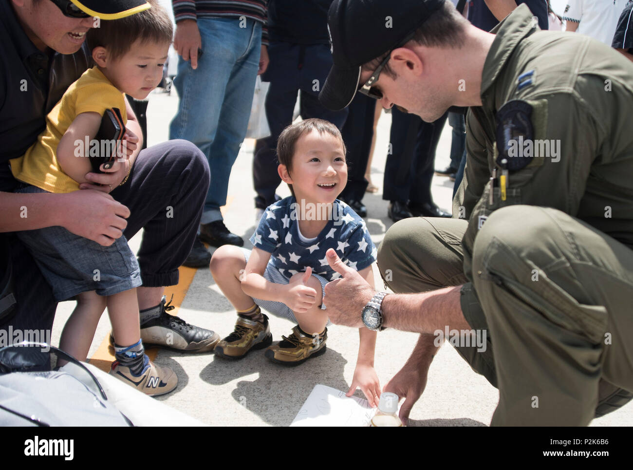 U.S. Air Force Capt. Dakota Newton, a Pacific Air Forces F-16 Demonstration Team safety observer, shares a thumbs up with a young boy during the Hofu Air Festival at Hofu-kita Air Base, Japan, May 21, 2017. The interaction with community is one aspect of the teams overall mission, the other being a display of the F-16 Fighting Falcons air power. (U.S. Air Force photo by Staff Sgt. Melanie Hutto) Stock Photo