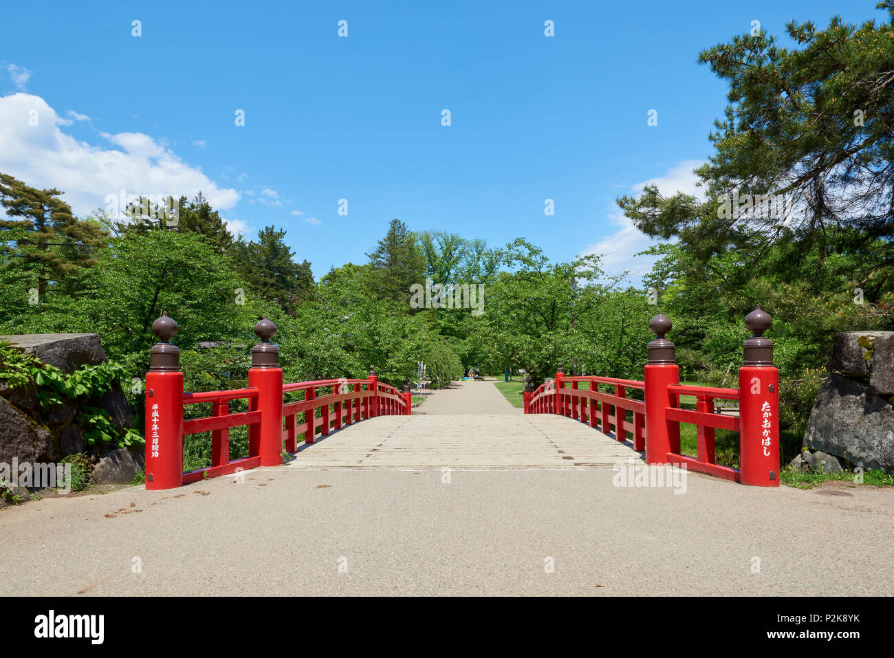 High angle shot of Takaokahashi Bridge framed by flowers and greenery in Hirosaki Park, Hirosaki, Japan. Stock Photo