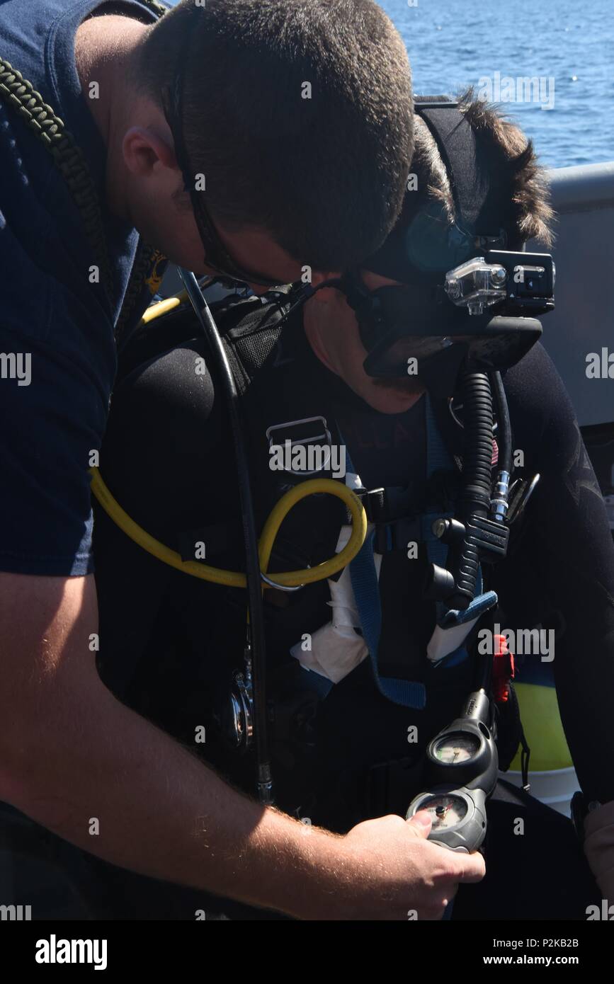 U.S. Navy Diver 1st Class Ben Eisenbarth and U.S. Navy Diver 2nd Class Kevin Kollar of Mobile Diving and Salvage Unit 2 inspect the oxygen gage prior to conduct an underwater recovery operation at Tyrrhenian Sea, Italy, Sept. 25, 2016. The Mobile Diving and Salvage Unit 2 is working with the Defense POW/MIAAccounting Agency (DPAA) to locate U.S. service members who went missing when a B-24 Liberator crashed during WWII. The mission of DPAA is to provide the fullest possible accounting for our missing personnel to their families and the nation. (U.S. Army photo by Spc. Lloyd Villanueva) Stock Photo