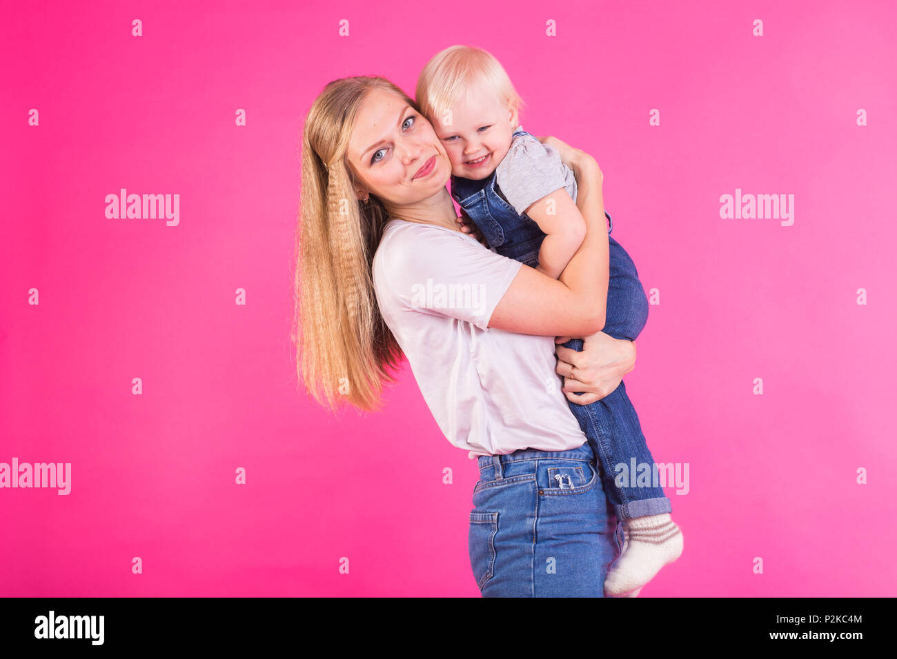 Funny family on pink background. Mother and her daughter girl. Mom and ...