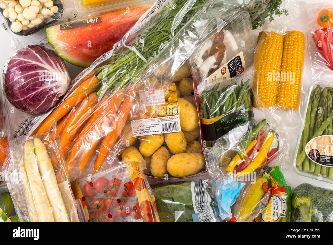 Fresh food, vegetables, fruit, each individually packaged in plastic wrap, all food is available in the same supermarket even without plastic packagin Stock Photo