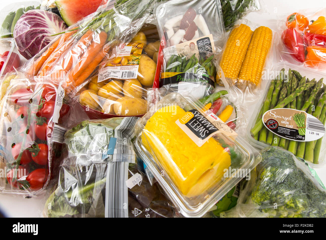 Fresh food, vegetables, fruit, each individually packaged in plastic wrap, all food is available in the same supermarket even without plastic packagin Stock Photo
