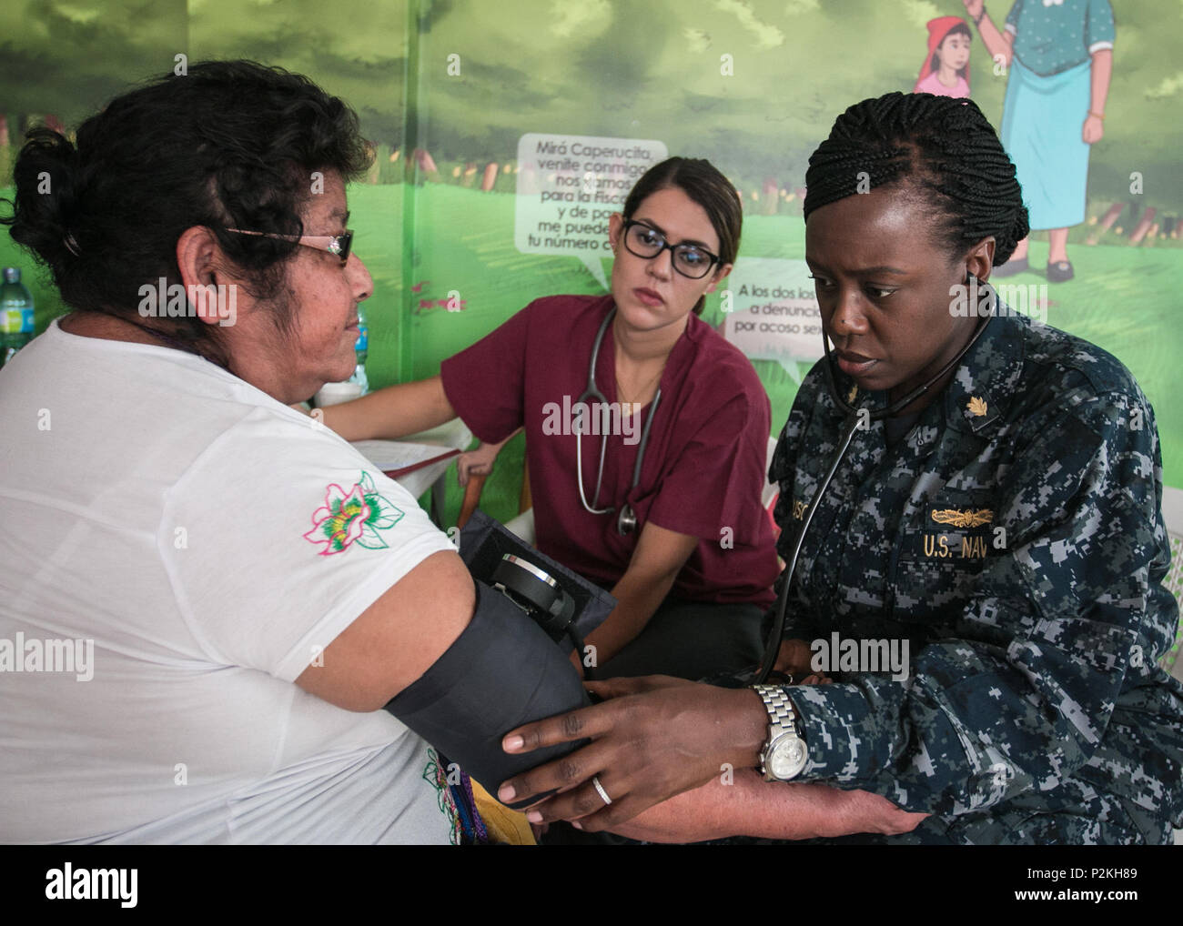 AHUACHAPAN, El Salvador (Sep. 8, 2016) – U.S. Navy Lt. Cmdr. Ebony Ferguson, a clinical nurse specialist assigned to Fort Belvoir, assists Dr. Gabriela Menjivar M.D., a health worker with Operation Blessing’s Medical Brigade, check a patient’s vitals at a temporary treatment site in Ahuachapán, El Salvador during Southern Partnership Station 2016 (SPS-16).  Operation Blessing’s Medical Brigade is a non-for-profit mobile patient care unit established to provide medical service to those affected by natural disaster and render aid to rural areas. SPS-16 is an annual series of U.S. Navy deployment Stock Photo