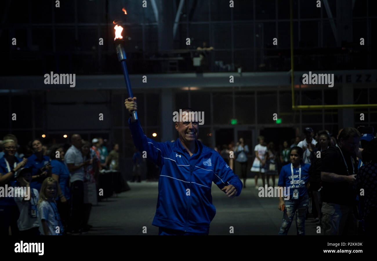 Shay Hampton, Department of Defense Warrior Games athlete and Team Air Force member, carries in the ceremonial Warrior Games torch to the event's closing ceremony at the Air Force Academy in Colorado Springs, Colorado, June 9, 2018. The Games will be held in Tampa, Florida, home of the SOCOM headquarters, in 2019.  (U.S. Air Force Photo by Senior Airman Dennis Hoffman) Stock Photo
