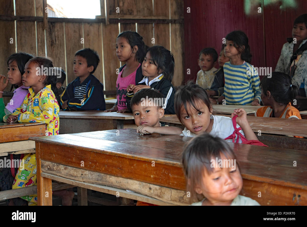 Cambodian children sitting at their desks in Ream local school listen to their teacher. Stock Photo