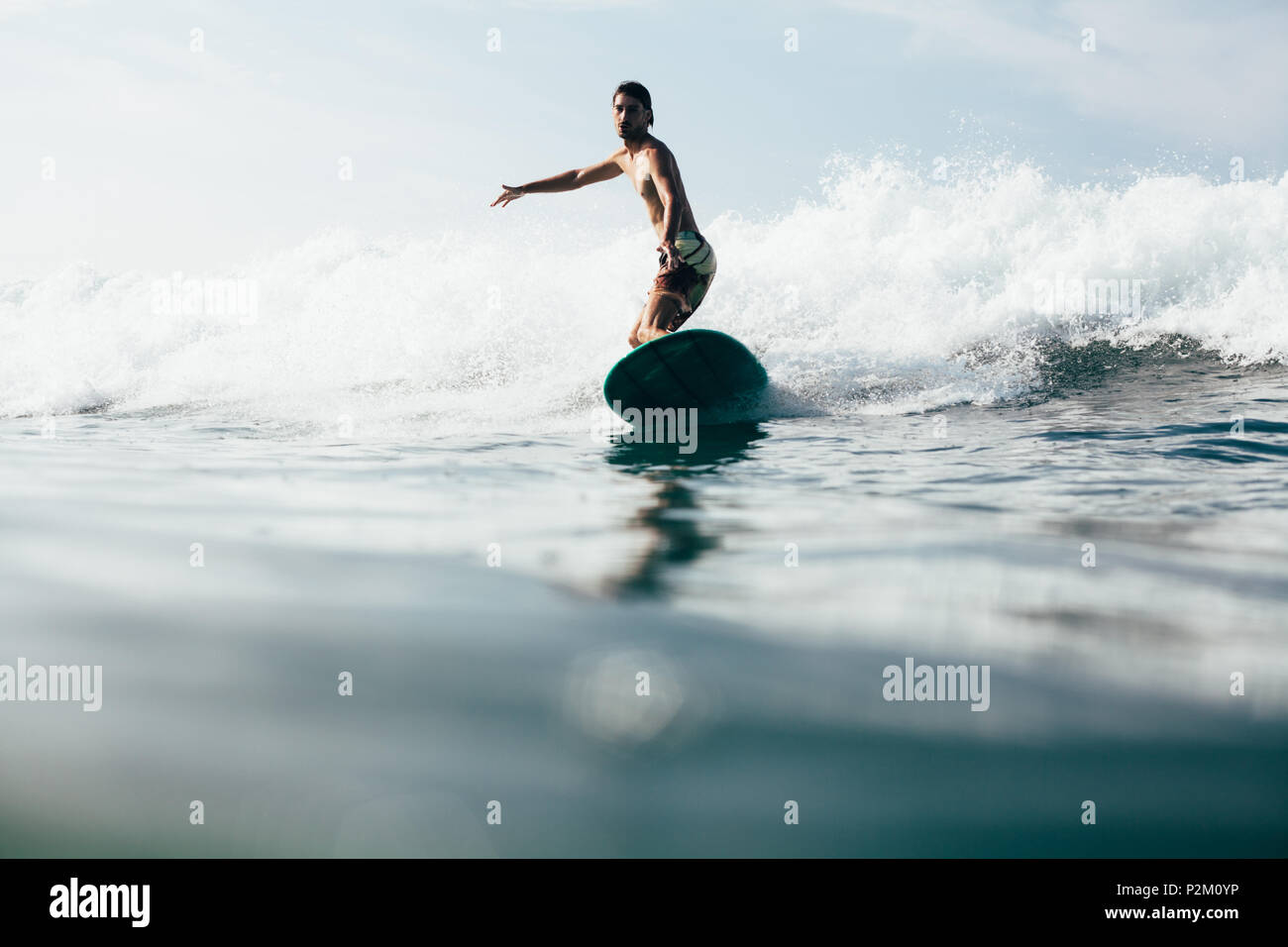 handsome man riding waves on surfboard while having vacation Stock ...