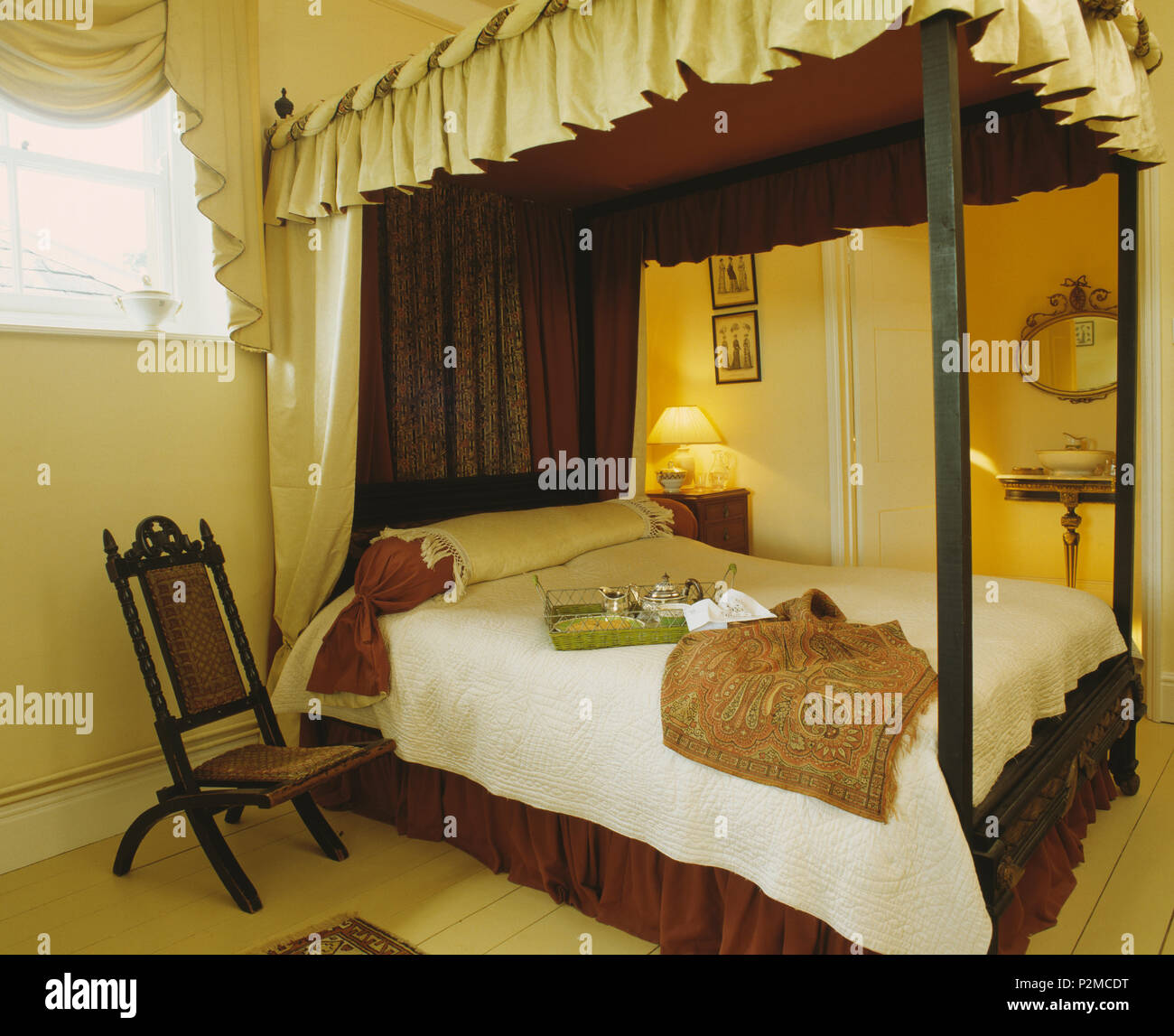 Cream and brown drapes on fourposter bed in cream bedroom with