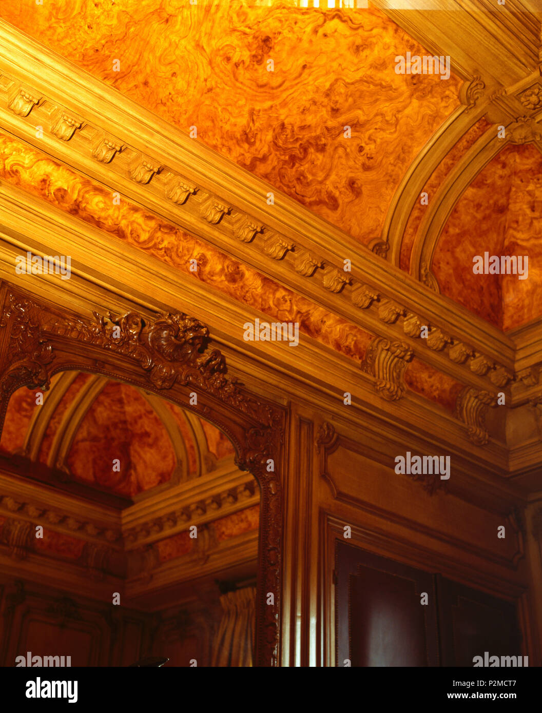 Close-up of red marble-effect ceiling and ornate cornice in hall in opulent Paris apartment Stock Photo