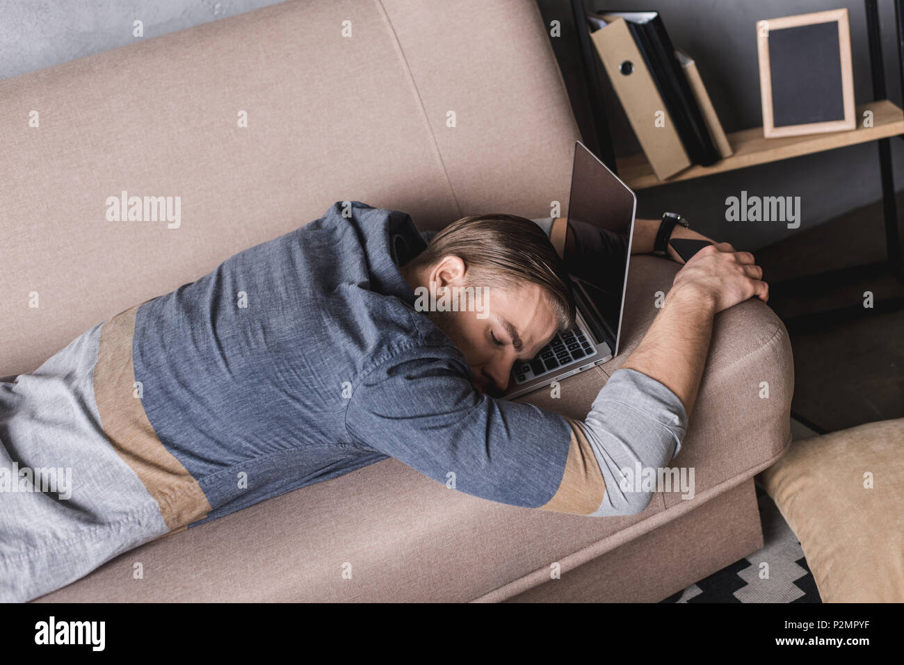 Ленивый работник. Занятой человек. Откладывать на потом. Начинающий бизнесмен. Муж на диване с ноутом.