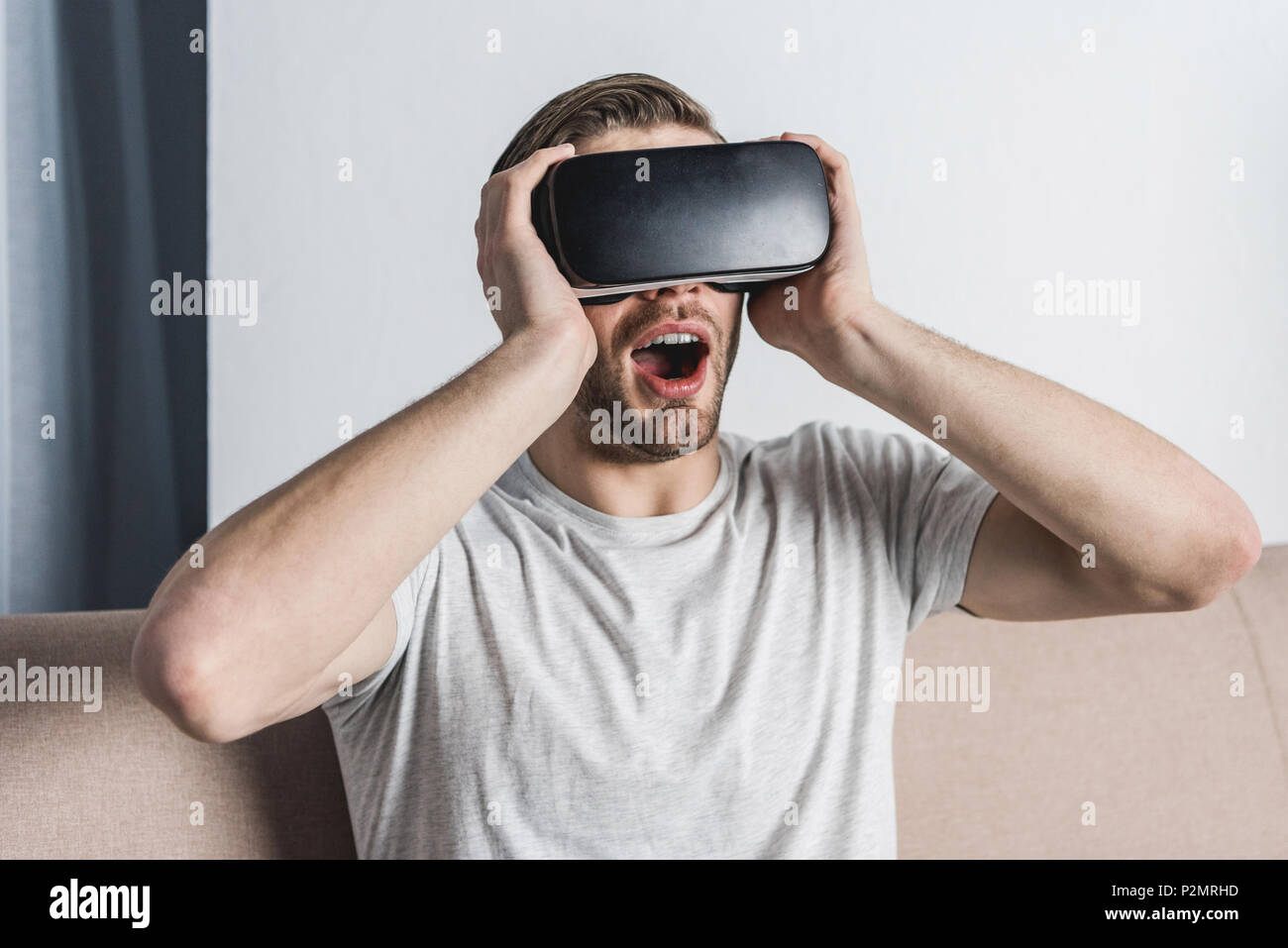 shocked young man in virtual reality headset Stock Photo