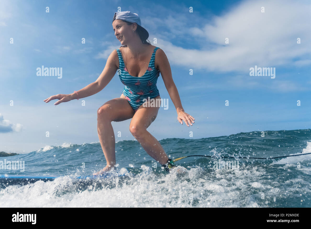 https://c8.alamy.com/comp/P2MXDE/side-view-of-woman-in-cap-and-swimming-suit-surfing-in-ocean-P2MXDE.jpg