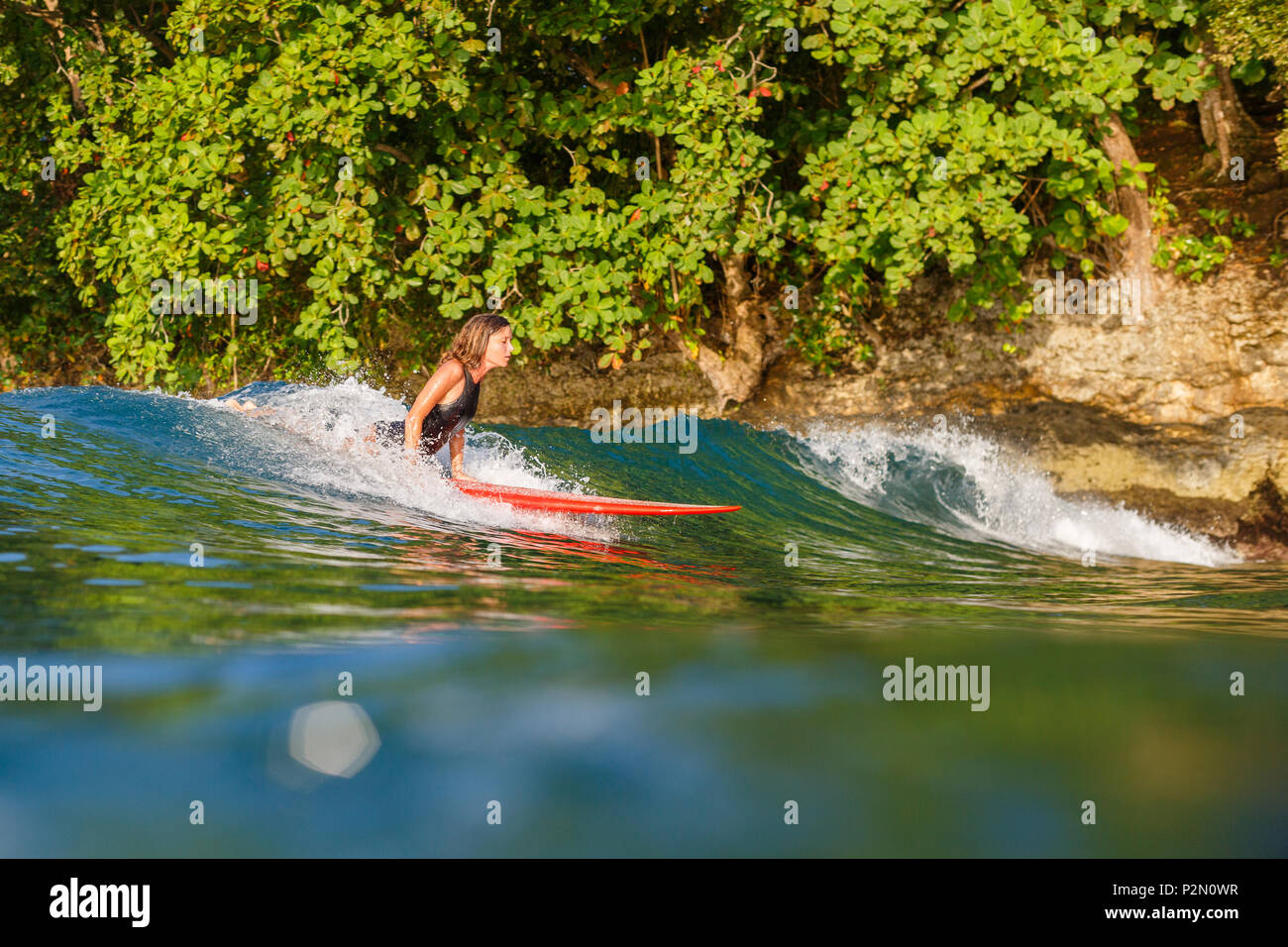 female surfer riding wave on surfboard in ocean Stock Photo - Alamy